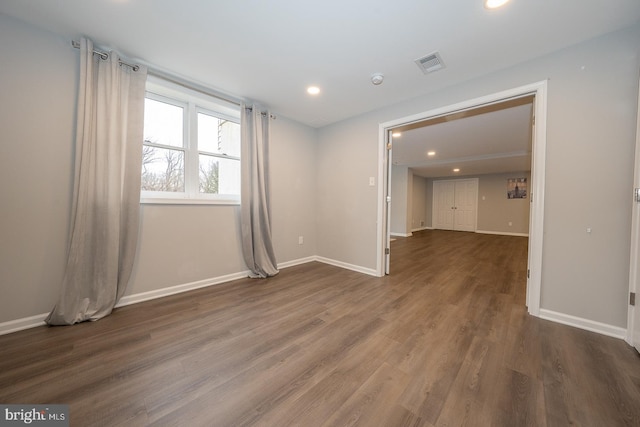 empty room with baseboards, visible vents, wood finished floors, and recessed lighting