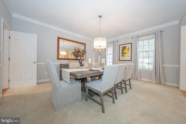 carpeted dining area featuring baseboards, ornamental molding, and a notable chandelier