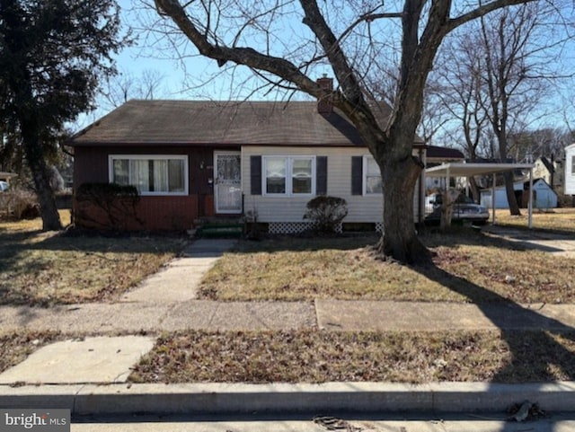 view of front of property featuring a chimney and an attached carport