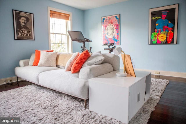 living area with dark wood-type flooring and baseboards