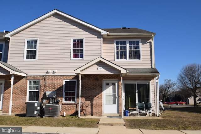 view of front of house with central AC and a front lawn