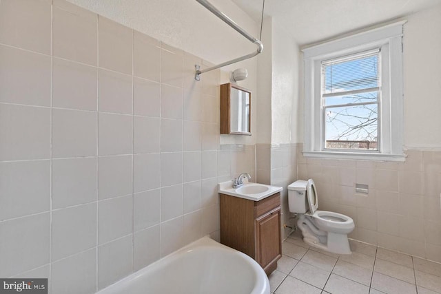 bathroom featuring shower / washtub combination, tile walls, toilet, vanity, and tile patterned flooring