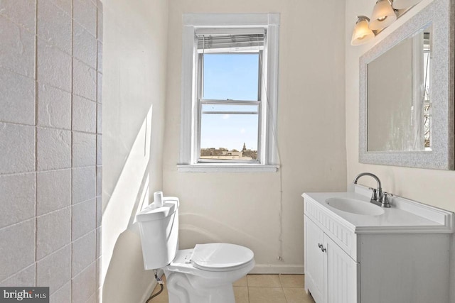 bathroom featuring toilet, tile patterned floors, baseboards, and vanity