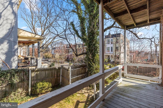 wooden terrace with a fenced backyard