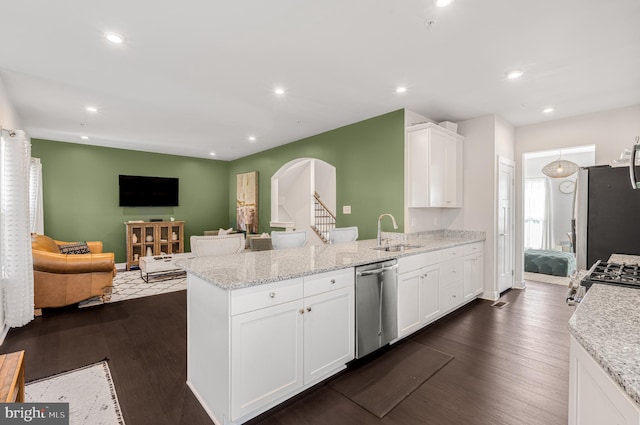 1603 Trotter St, Frederick, MD 21702 - kitchen with stainless steel appliances, a peninsula, white cabinets, light stone counters, and dark wood-type flooring