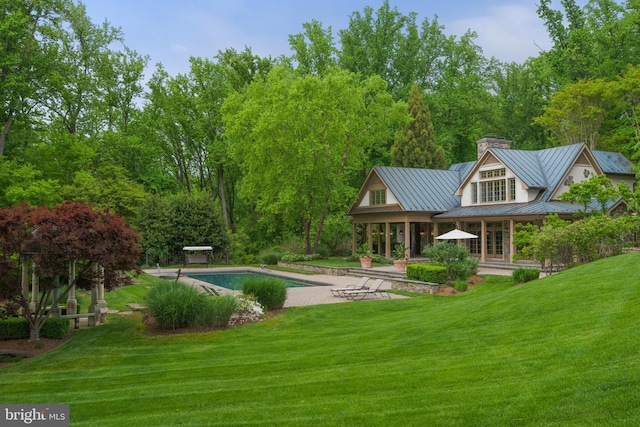 938 Old County Rd, Severna Park, MD 21146 - back of house featuring a standing seam roof, a chimney, a lawn, an outdoor pool, and a patio