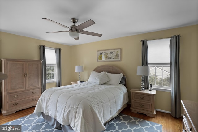 bedroom featuring light wood-type flooring, ceiling fan, and baseboards