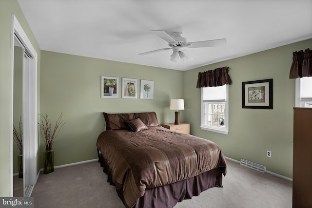 bedroom featuring baseboards, visible vents, a ceiling fan, and light colored carpet