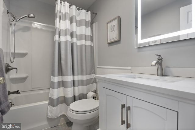 bathroom featuring toilet, wainscoting, shower / bath combination with curtain, and vanity