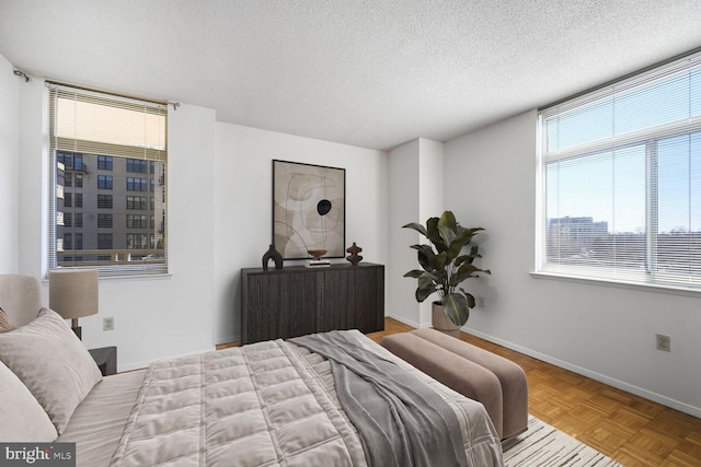 bedroom featuring a textured ceiling and baseboards