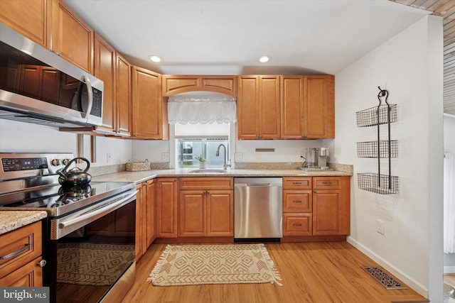 2832 Larkin Rd, Upper Chichester, PA 19061 - kitchen featuring stainless steel appliances, a sink, light wood-type flooring, light stone countertops, and baseboards