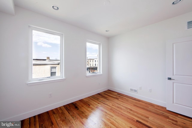 unfurnished room with a wealth of natural light and light hardwood / wood-style flooring