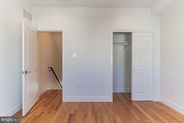 unfurnished bedroom featuring light wood-type flooring and a closet