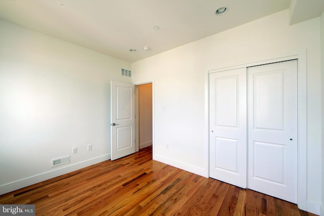 unfurnished bedroom featuring dark wood-type flooring and a closet