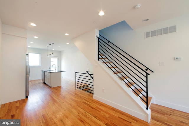 stairway with sink and hardwood / wood-style floors