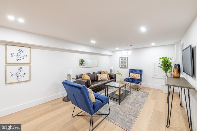 living area featuring light wood-type flooring, baseboards, and recessed lighting