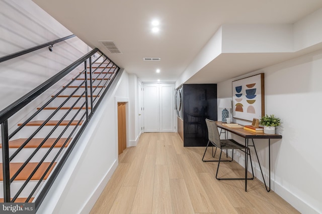 corridor with stairs, visible vents, and light wood-style floors