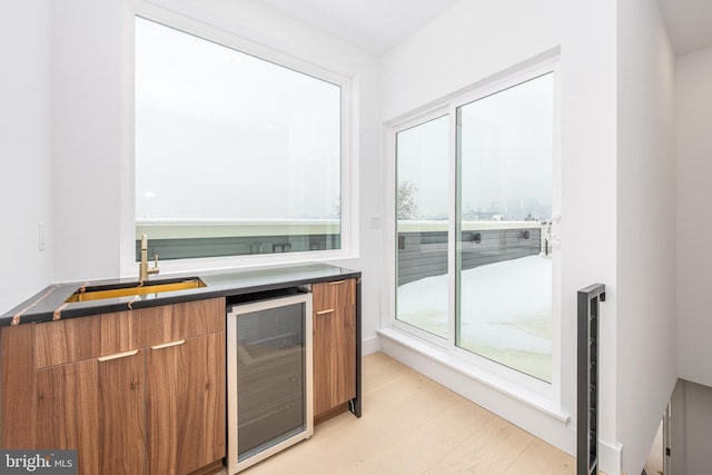 bar with a wealth of natural light, wine cooler, indoor wet bar, and a sink