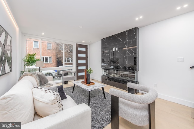 living area with recessed lighting, baseboards, and wood finished floors