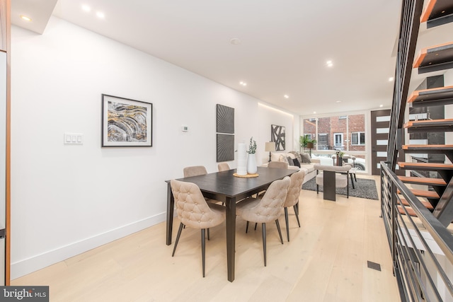 dining space featuring light wood-style floors, recessed lighting, stairway, and baseboards