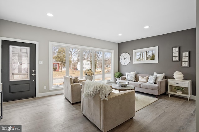 living area with light wood-style flooring, baseboards, and recessed lighting