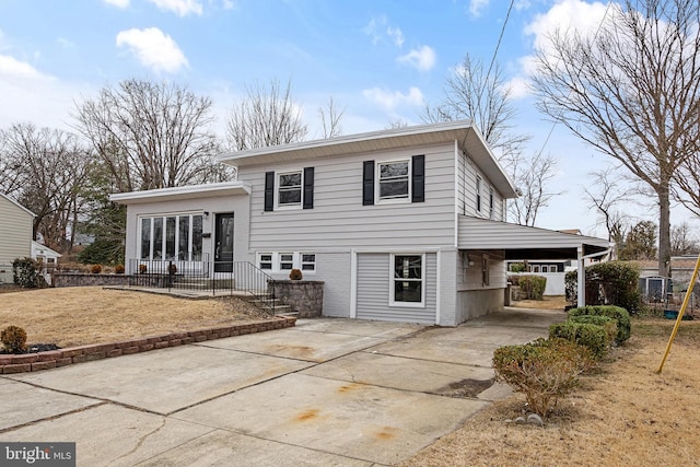 back of property with an attached carport and concrete driveway