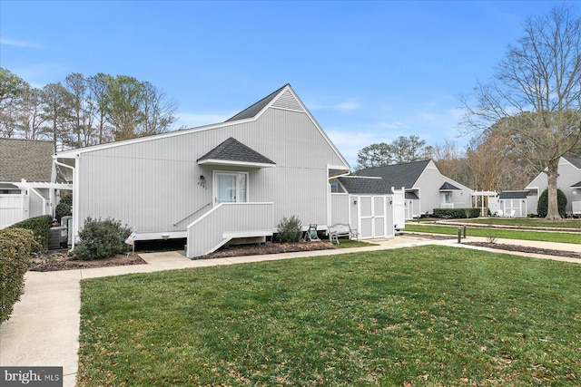 view of front of property featuring roof with shingles, a front yard, and central air condition unit