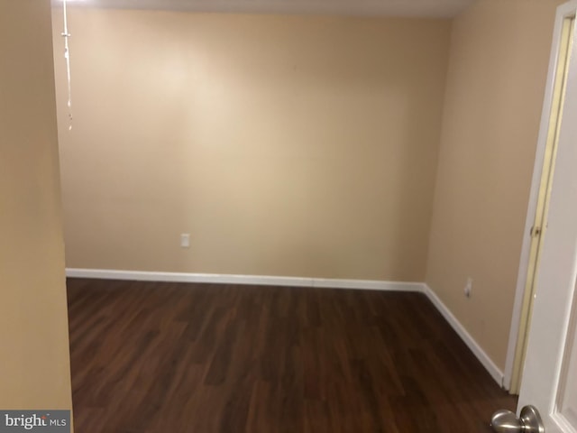 empty room with dark hardwood / wood-style flooring