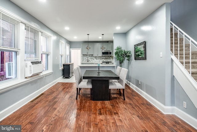 dining space featuring dark wood-style flooring, stairway, cooling unit, and baseboards