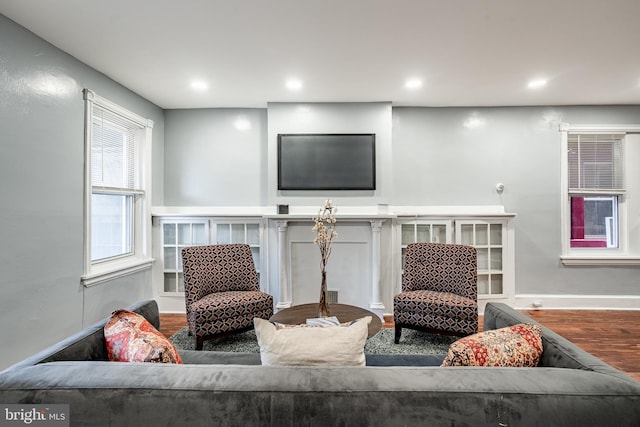 sitting room featuring baseboards, wood finished floors, and recessed lighting