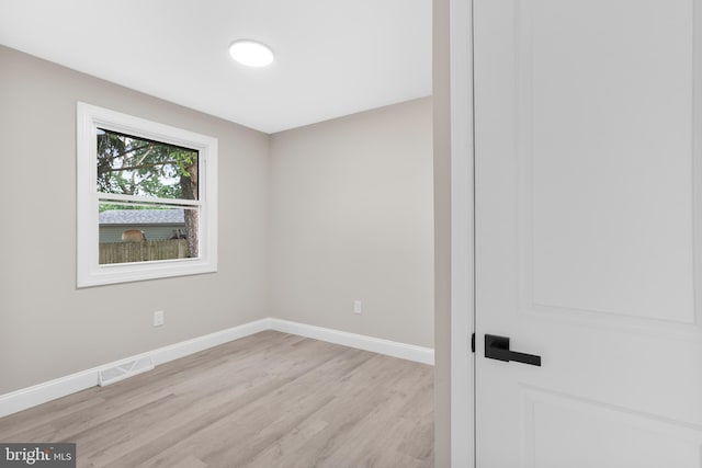 spare room with light wood finished floors and baseboards