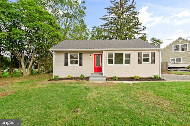 view of front of property with a front lawn and roof with shingles