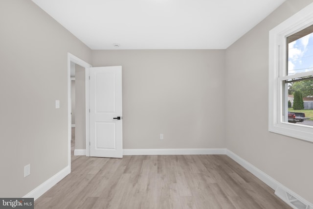 spare room with light wood-type flooring and baseboards