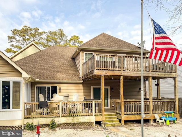 back of property featuring a deck and roof with shingles