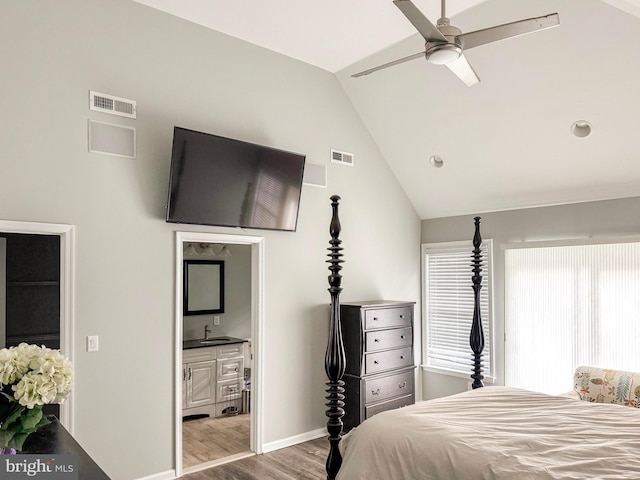 bedroom with light hardwood / wood-style flooring, sink, vaulted ceiling, and ensuite bath