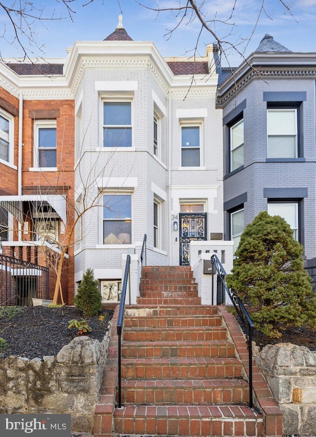 townhome / multi-family property featuring stairway and brick siding