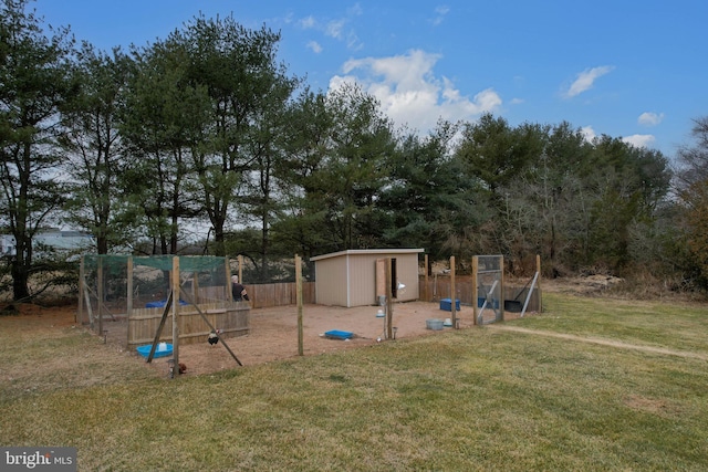 view of playground with a shed, an outdoor structure, fence, and a lawn