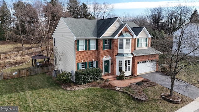 view of front of home with a garage, a front lawn, and central AC unit