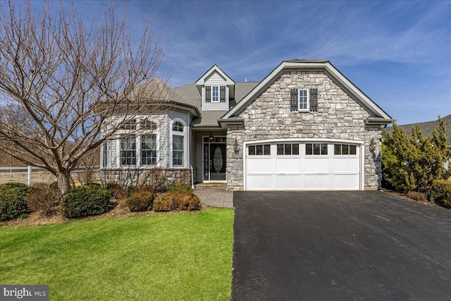 view of front of house featuring a front lawn, a garage, stone siding, and driveway