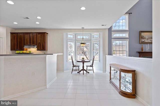 kitchen featuring visible vents, under cabinet range hood, decorative light fixtures, recessed lighting, and light tile patterned floors