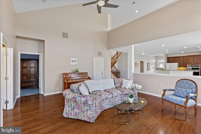 living area featuring visible vents, stairs, ceiling fan, and wood finished floors