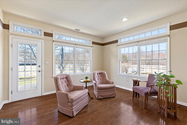 sitting room featuring dark wood-style floors, plenty of natural light, and baseboards