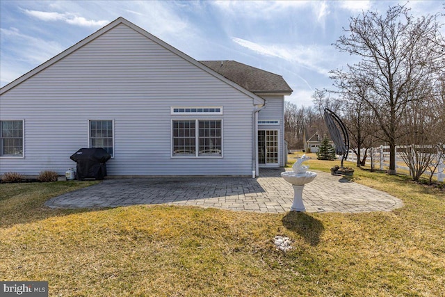 rear view of property featuring a patio area and a yard