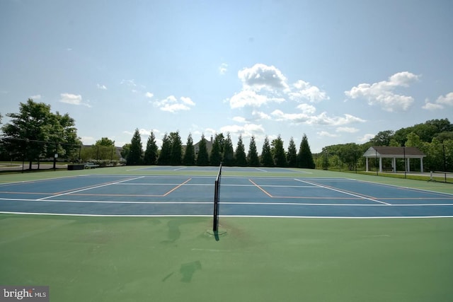 view of tennis court featuring community basketball court and fence