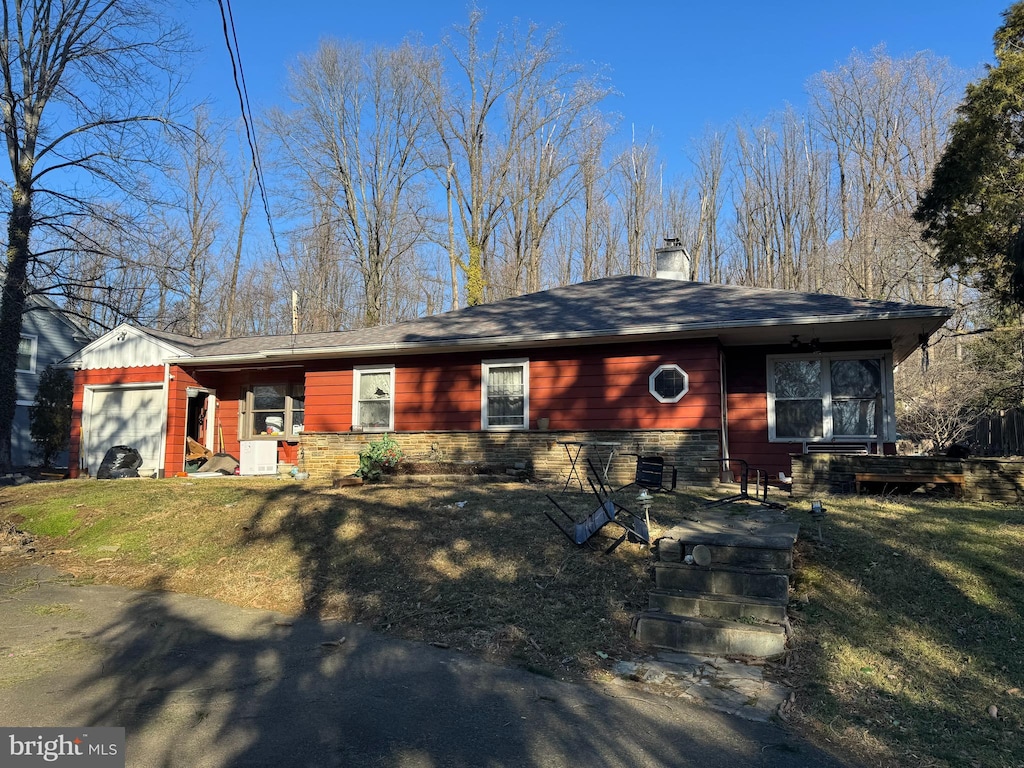 ranch-style home with a front lawn and a garage