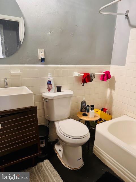 bathroom with vanity, toilet, and a bath