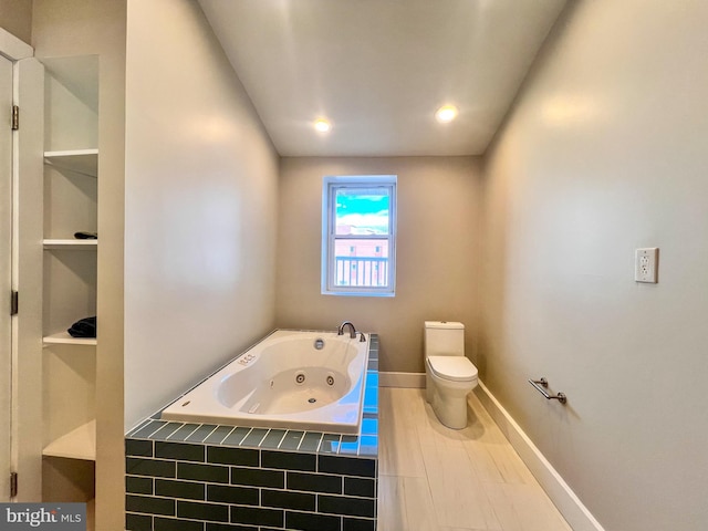 bathroom featuring tiled bath and toilet