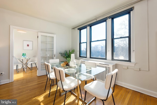 dining space featuring wood-type flooring, plenty of natural light, and baseboards