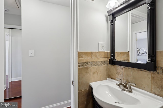 bathroom featuring sink and tile walls