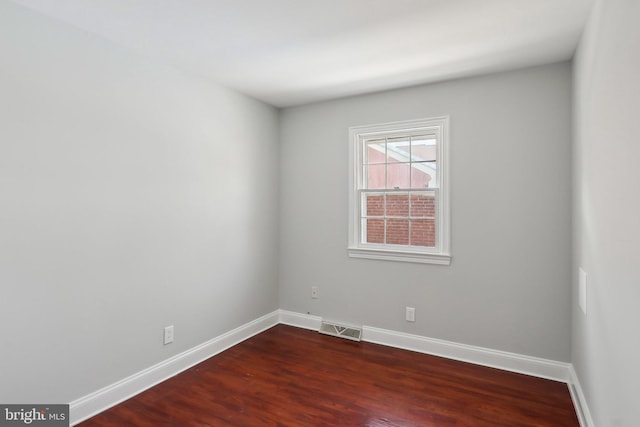 unfurnished room with dark wood-type flooring